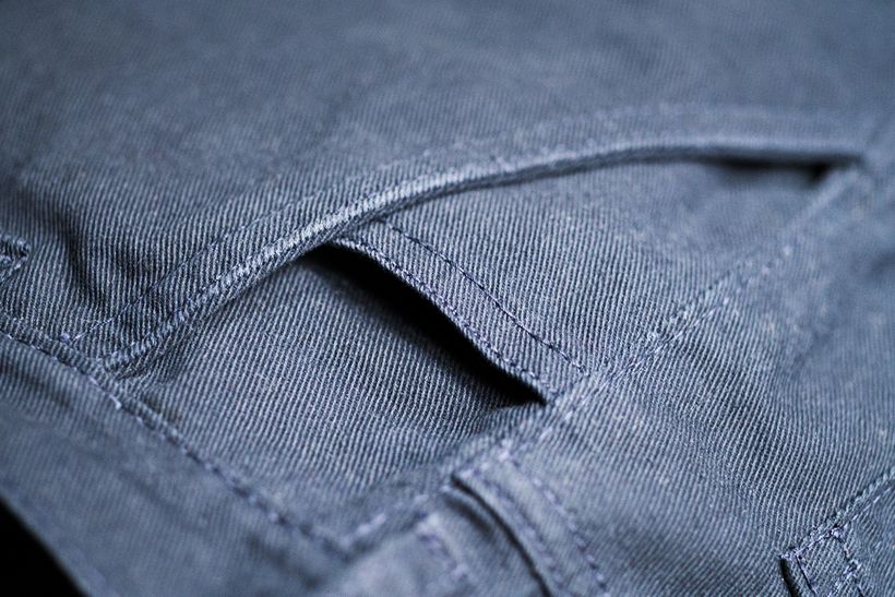Nahaufnahme der Eingrifftasche einer graublauen Baumwollhose.